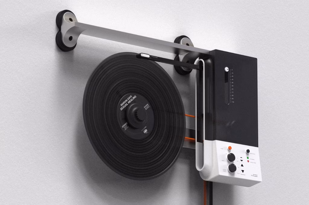 A modern, wall-mounted record player with a black vinyl record of Marvin Gaye's "Sexual Healing" playing, featuring a sleek silver arm and a black and white control unit. - midnightrebels.com