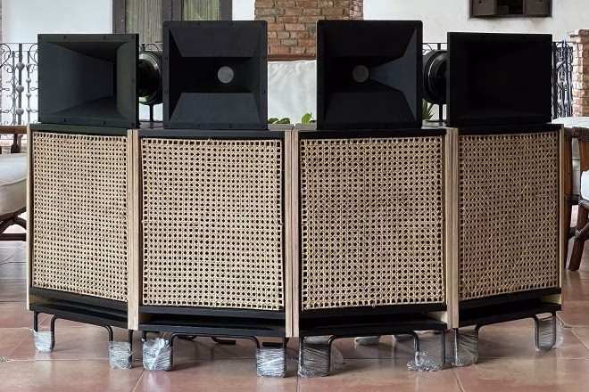 A set of four Fatima Sound Hi-Fi speakers made in the Philippines, featuring large black horn tweeters atop cabinets with woven rattan panels, are displayed on a terracotta-colored floor. - midnightrebels.com