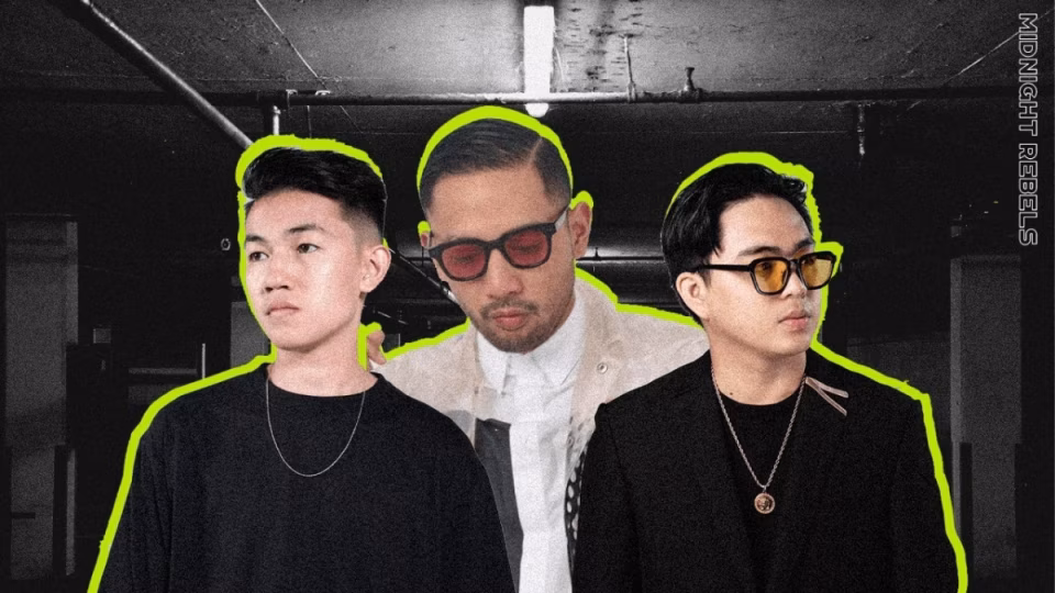 The image shows the group Midnight Rebels, three Filipino DJs with stylish outfits and sunglasses, promoting their music against a gritty, urban background. - midnightrebels.com