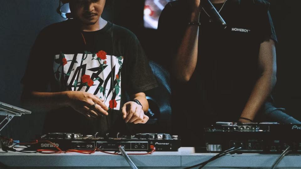 Close-up of two DJs performing live, showcasing their gear and skills, relevant to discussions about DJ talent fee adjustments for 2025. - midnightrebels.com