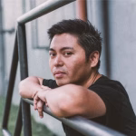 Portrait of Manila-based techno artist Alinep, celebrating the release of FUTURA 101 EP on Dubfire's SCI+TEC label. He is leaning on a metal railing, looking directly at the camera. - midnightrebels.com