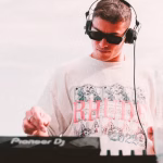 Young DJ wearing headphones and sunglasses, focused on mixing with Pioneer DJ equipment. Demonstrates the accessibility of DJing in 2025, prompting the question of how to stand out in a saturated market. - midnightrebels.com
