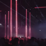A crowd of people dance under vibrant red spotlights at an underground dance music event, reflecting the energy of Gen X leading the scene. - midnightrebels.com