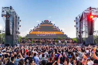 Solomun live music festival, large crowd, pyramid stage with neon lights.