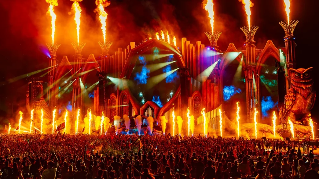 Tomorrowland music festival stage with flames and crowd.