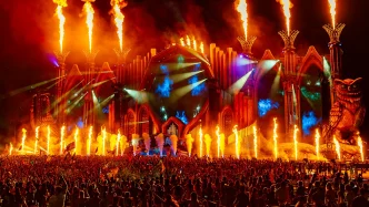 Tomorrowland music festival stage with flames and crowd.