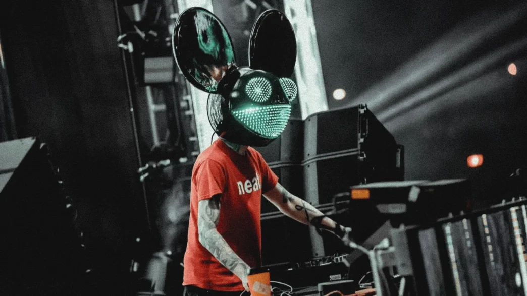 Deadmau5 DJ performs in lighted mouse mask and red shirt.