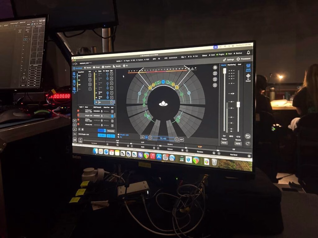 Audio engineer workstation: monitor displaying mixing and mastering software interface.