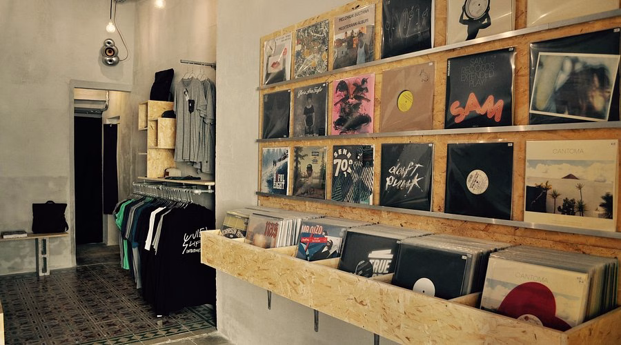 Cool record store interior with vinyl records and clothing racks.