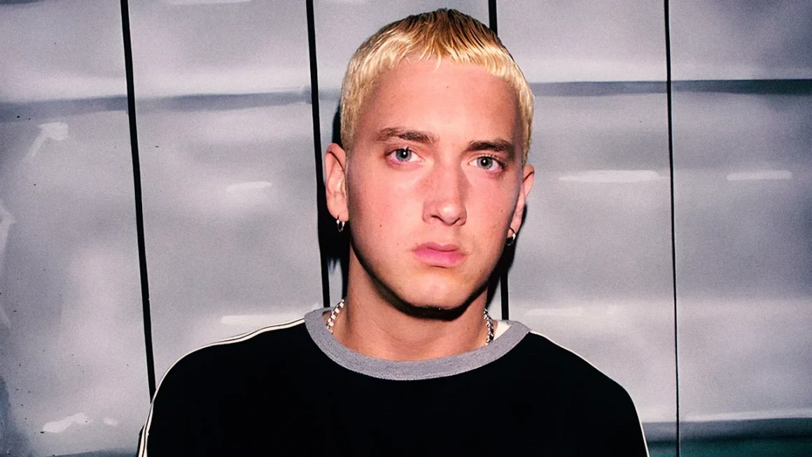 Portrait of young rapper Eminem with bleached blonde hair and a serious expression.