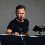 Focused DJ playing electronic music on Pioneer gear.